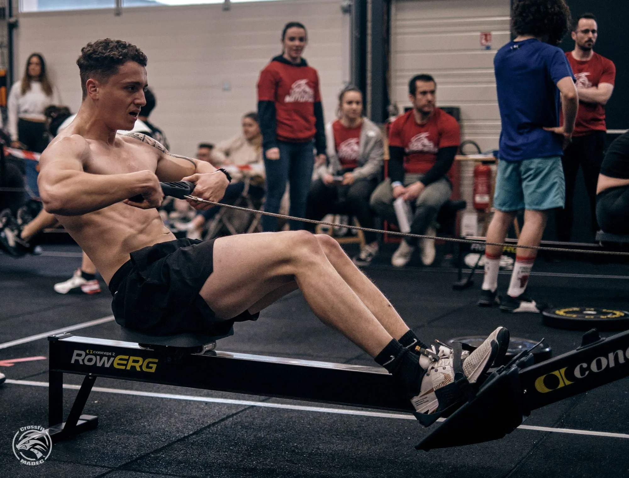 Athlète au rameur pendant une compétition CrossFit MADEC